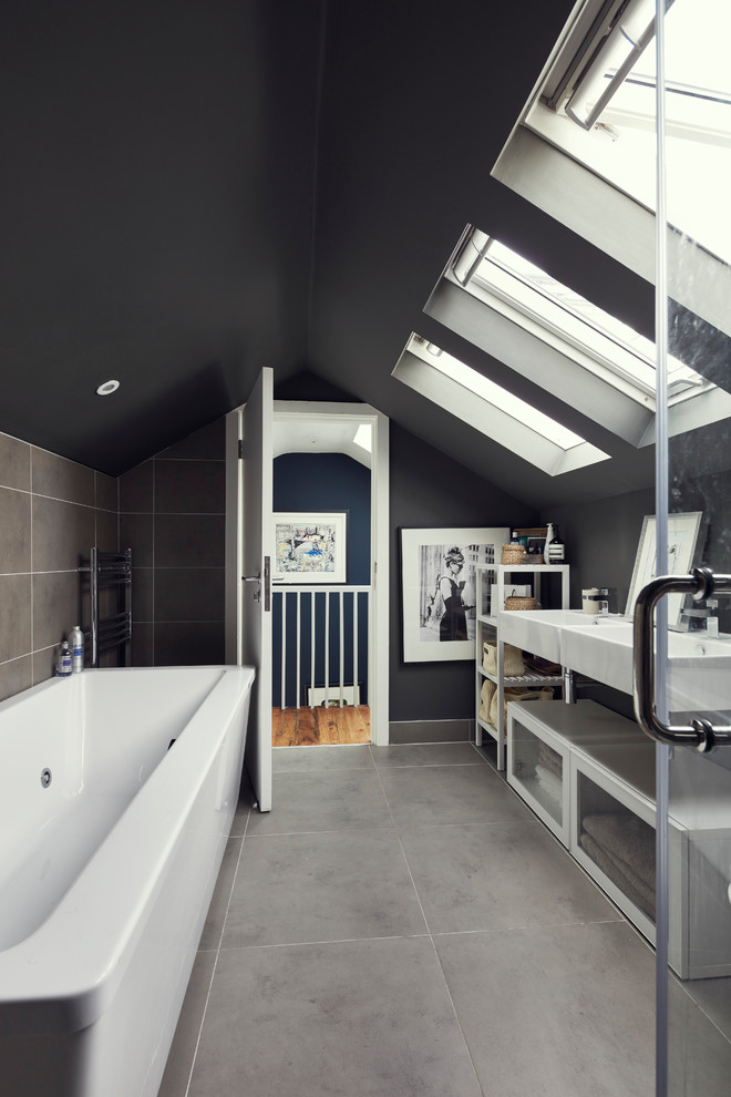 Cette image montre une salle d'eau design avec un placard à porte vitrée, des portes de placard blanches, une baignoire en alcôve, un combiné douche/baignoire, un carrelage gris et un lavabo suspendu.