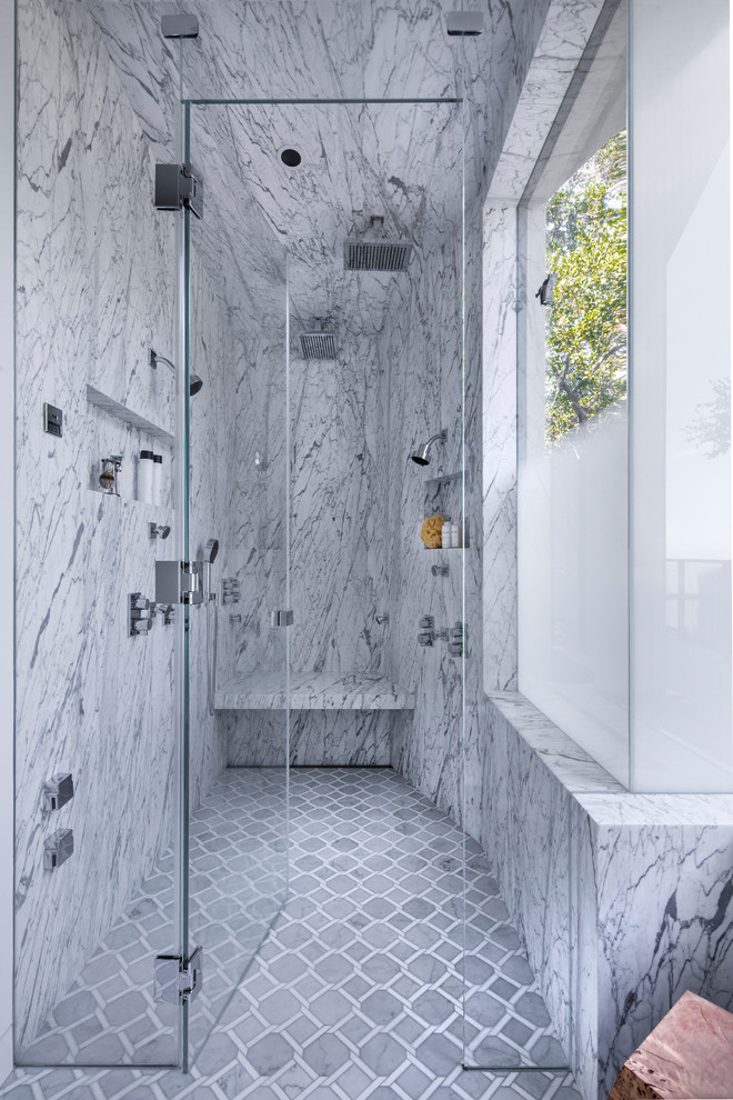 Cette image montre une salle de bain principale design avec une douche à l'italienne, un carrelage gris, des dalles de pierre, un mur gris, un sol gris, une cabine de douche à porte battante et une fenêtre.