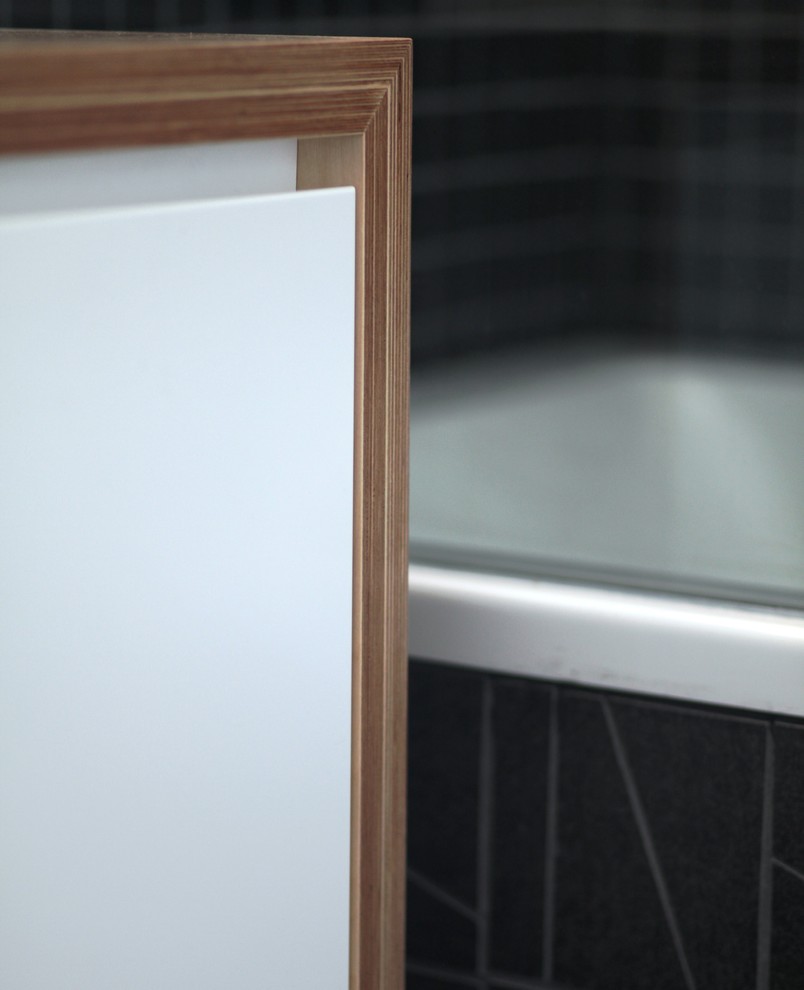 Foto di una stanza da bagno padronale contemporanea di medie dimensioni con ante bianche, top in legno, vasca/doccia, piastrelle nere, pareti bianche, lavabo a consolle e WC a due pezzi
