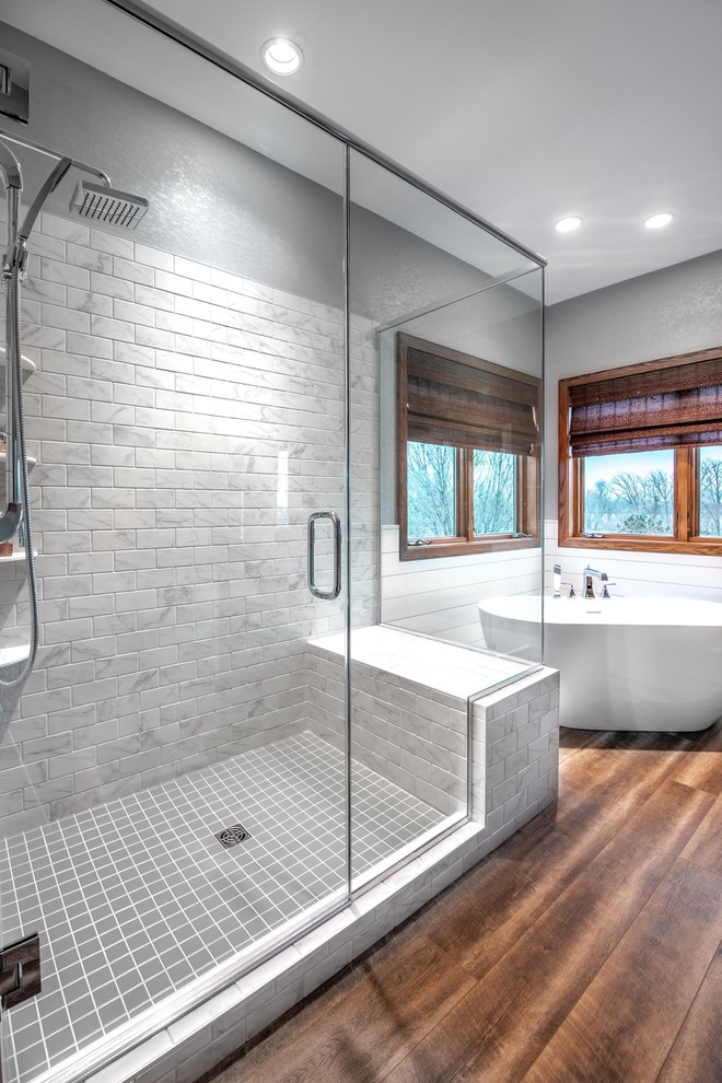 Bathroom - mid-sized farmhouse master gray tile and ceramic tile vinyl floor and brown floor bathroom idea in Other with raised-panel cabinets, gray cabinets, gray walls, an integrated sink, solid surface countertops and a hinged shower door