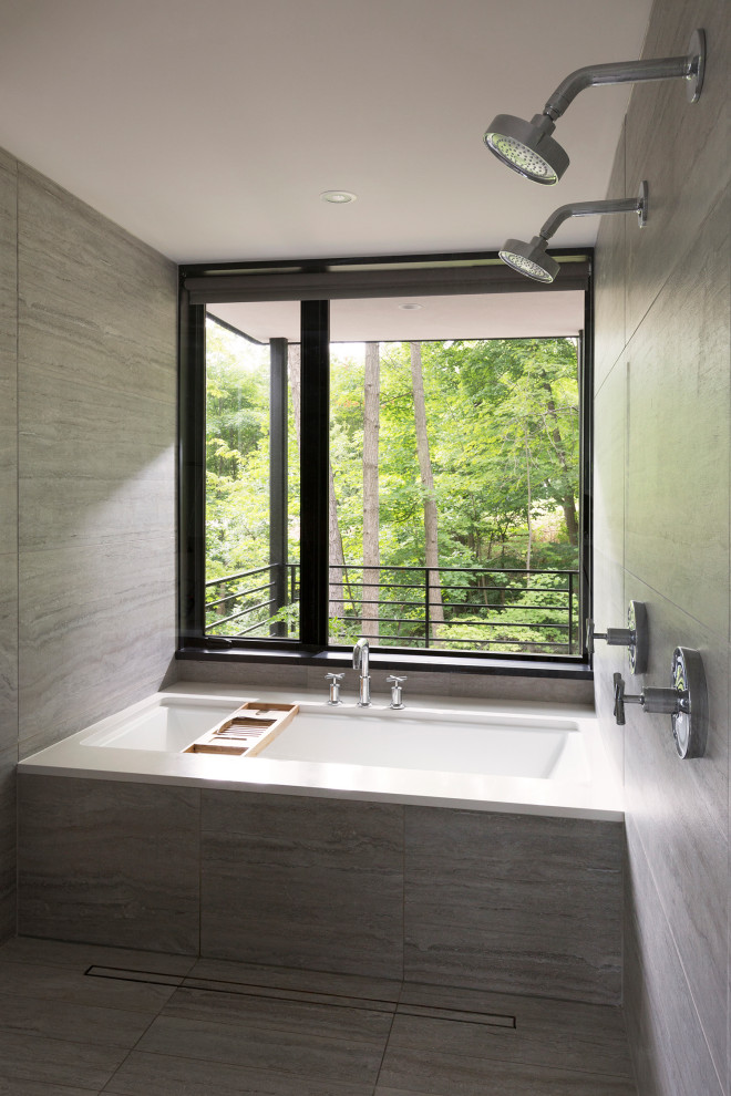 Cette photo montre une petite salle de bain principale moderne avec une baignoire en alcôve, un espace douche bain, un carrelage gris, un mur gris, un sol gris et une cabine de douche à porte battante.