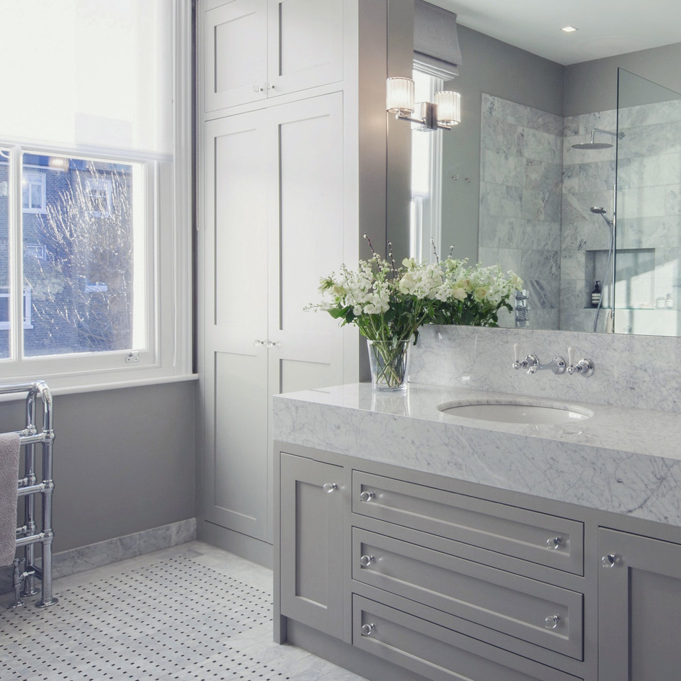 Идея дизайна: большая главная ванная комната в современном стиле с фасадами с утопленной филенкой, серыми фасадами, накладной ванной, душевой комнатой, инсталляцией, серой плиткой, мраморной плиткой, серыми стенами, полом из мозаичной плитки, монолитной раковиной, мраморной столешницей, серым полом и открытым душем