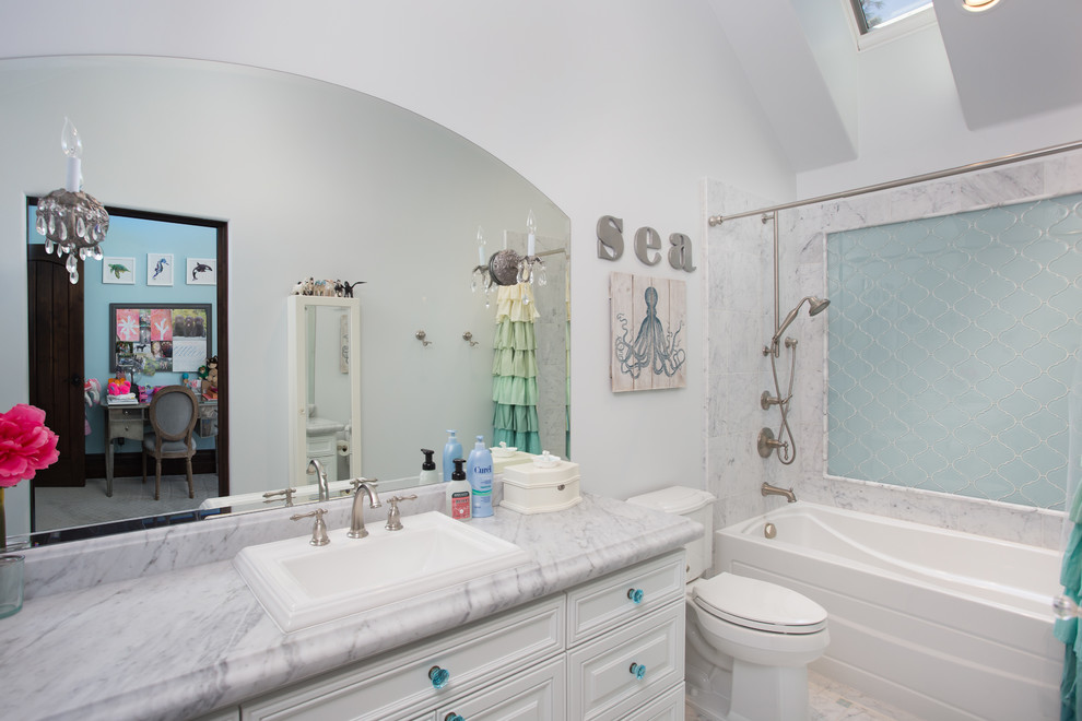Стильный дизайн: детская ванная комната среднего размера в классическом стиле с белыми фасадами, ванной в нише, душем над ванной, раздельным унитазом, разноцветной плиткой, стеклянной плиткой, белыми стенами, мраморным полом, накладной раковиной, мраморной столешницей, разноцветным полом, шторкой для ванной и фасадами с утопленной филенкой - последний тренд