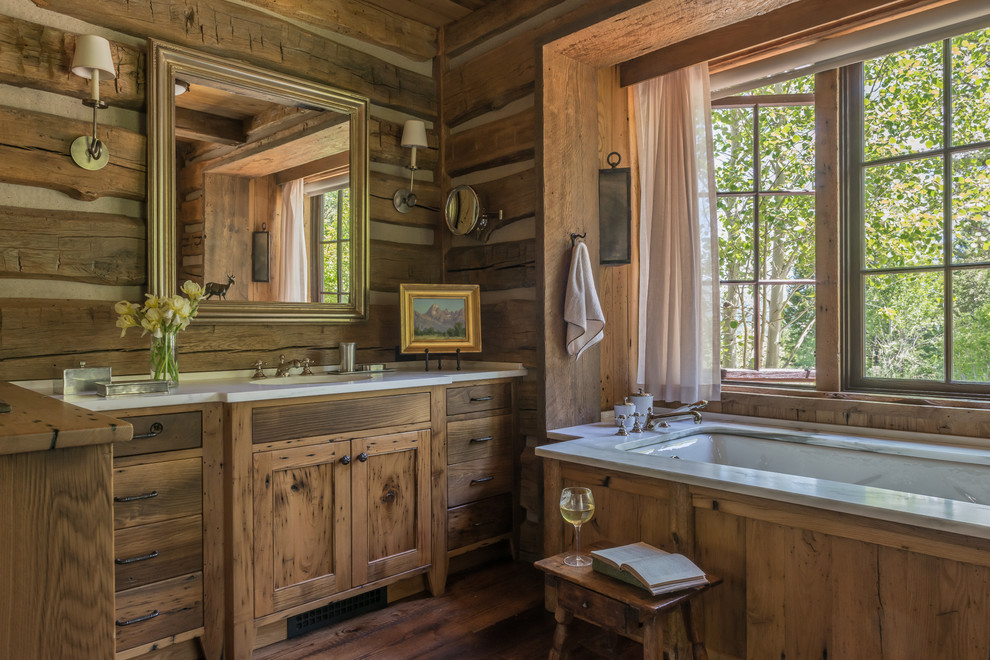 Rustic ensuite bathroom in Other with medium wood cabinets, a submerged bath, dark hardwood flooring, brown floors and white worktops.