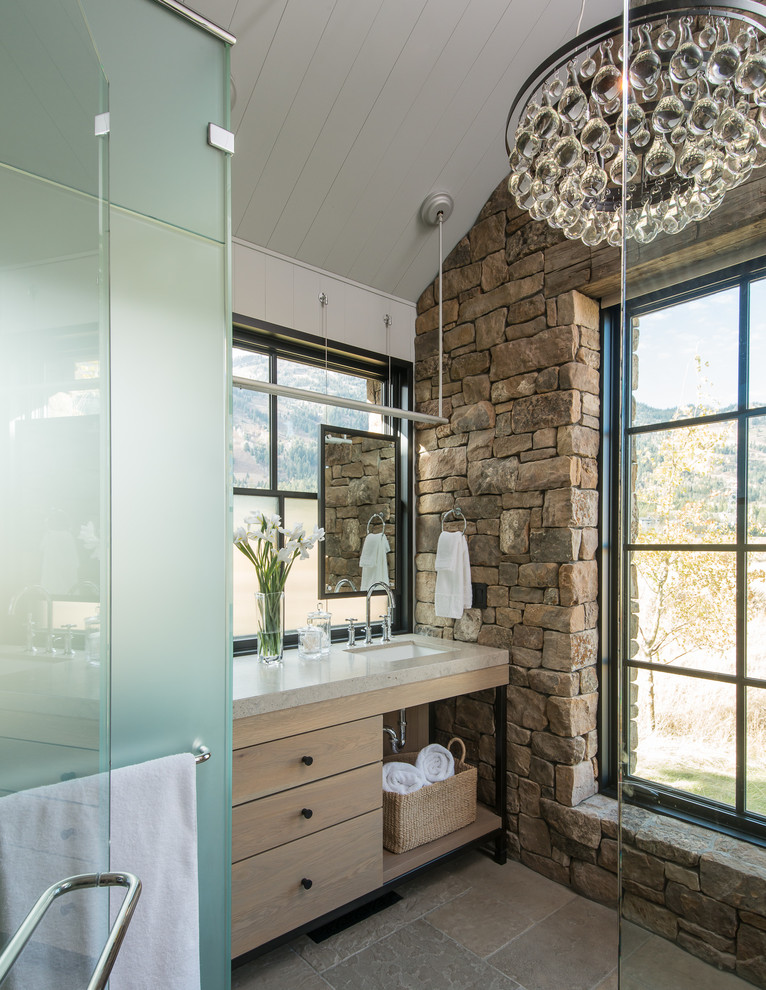 Imagen de cuarto de baño principal rural de tamaño medio con puertas de armario de madera clara, paredes marrones, suelo de piedra caliza, lavabo integrado, encimera de granito y armarios con paneles lisos