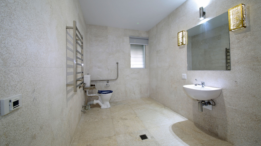 Пример оригинального дизайна: большая ванная комната в современном стиле с светлыми деревянными фасадами, отдельно стоящей ванной, угловым душем, раздельным унитазом, разноцветной плиткой, каменной плиткой, разноцветными стенами, подвесной раковиной, столешницей из оникса, разноцветным полом, открытым душем и белой столешницей