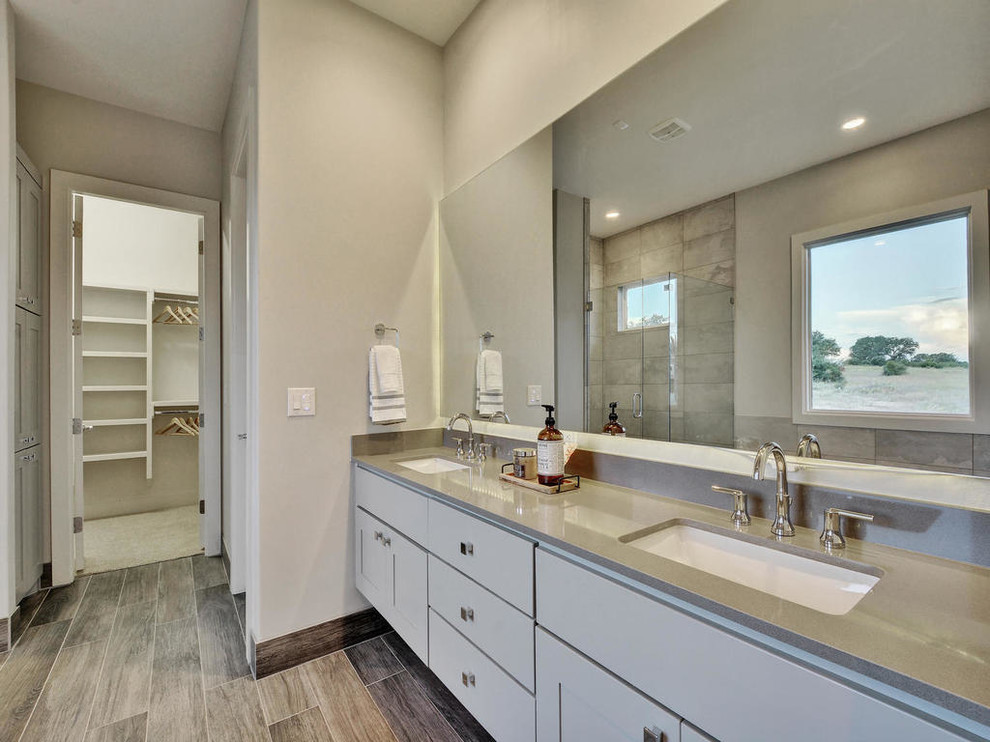 Large contemporary ensuite bathroom in Austin with shaker cabinets, grey cabinets, a corner shower, grey tiles, porcelain tiles, grey walls, porcelain flooring, a submerged sink, engineered stone worktops, brown floors, a hinged door and a built-in bath.