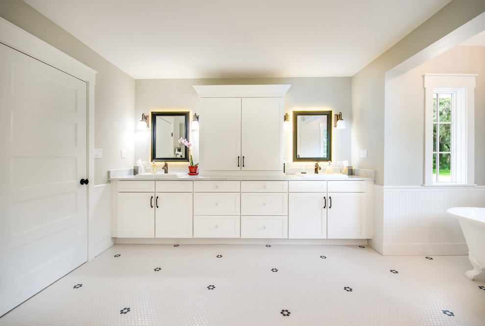 Bild på ett stort lantligt en-suite badrum, med skåp i shakerstil, vita skåp, ett fristående badkar, en öppen dusch, en toalettstol med separat cisternkåpa, flerfärgad kakel, keramikplattor, grå väggar, klinkergolv i keramik, ett nedsänkt handfat, marmorbänkskiva, vitt golv och med dusch som är öppen