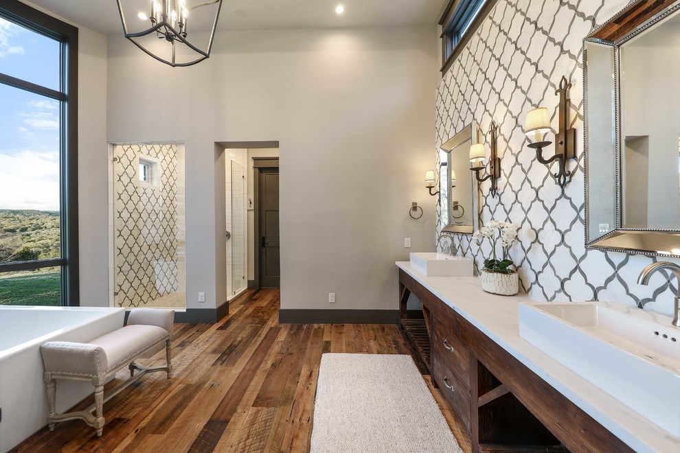 Design ideas for an expansive rustic ensuite bathroom in Austin with medium wood cabinets, white tiles, grey walls, medium hardwood flooring, brown floors and a hinged door.
