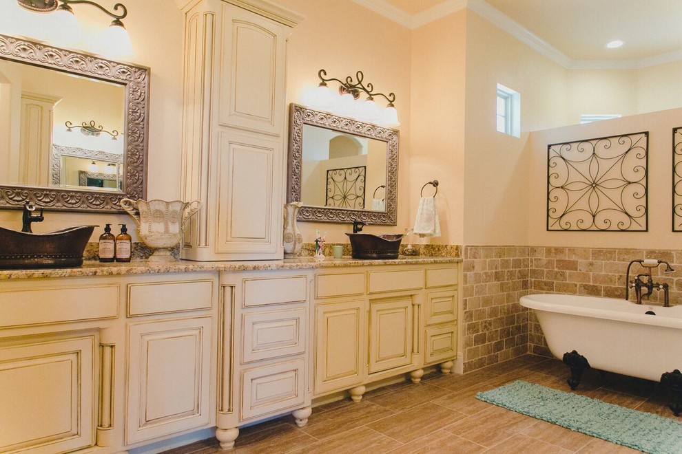 Bild på ett stort rustikt en-suite badrum, med vita skåp, ett fristående handfat, granitbänkskiva, luckor med upphöjd panel, ett badkar med tassar, brun kakel, tunnelbanekakel, beige väggar, klinkergolv i porslin, brunt golv, en öppen dusch, en toalettstol med separat cisternkåpa och med dusch som är öppen