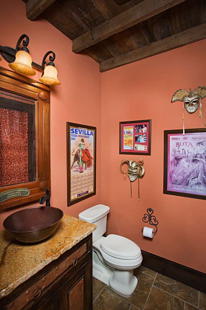 Foto di una stanza da bagno mediterranea con lavabo a bacinella, ante in legno bruno e pareti arancioni