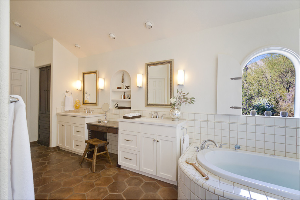 Aménagement d'une salle de bain sud-ouest américain avec un placard à porte shaker, des portes de placard blanches, une baignoire posée et un carrelage blanc.