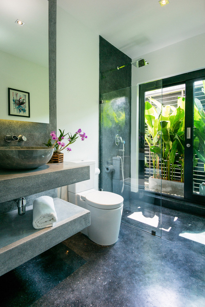 Design ideas for a medium sized contemporary ensuite bathroom in Other with grey cabinets, a walk-in shower, a one-piece toilet, grey tiles, stone slabs, white walls, concrete flooring, concrete worktops, black floors, grey worktops, a vessel sink and an open shower.