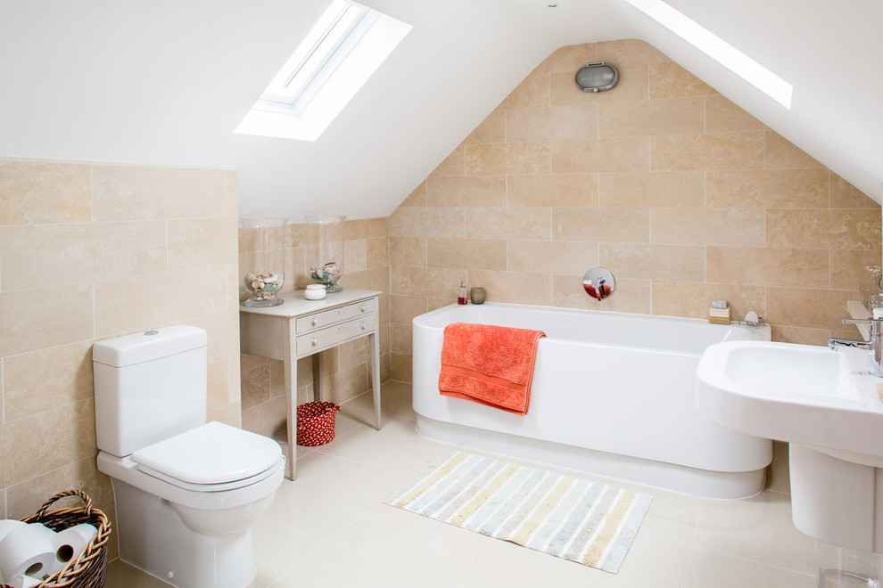 Cette photo montre une salle de bain bord de mer de taille moyenne avec un carrelage beige, des carreaux de céramique, un mur beige, un sol en carrelage de céramique, un lavabo suspendu, un sol gris, une baignoire posée et WC séparés.