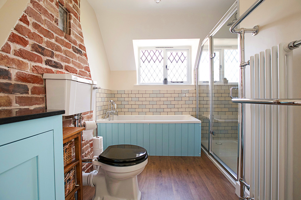 Свежая идея для дизайна: ванная комната в стиле неоклассика (современная классика) с фасадами в стиле шейкер, синими фасадами, накладной ванной, угловым душем, раздельным унитазом, бежевой плиткой, синей плиткой, плиткой кабанчик, бежевыми стенами, темным паркетным полом, душевой кабиной, коричневым полом и душем с распашными дверями - отличное фото интерьера