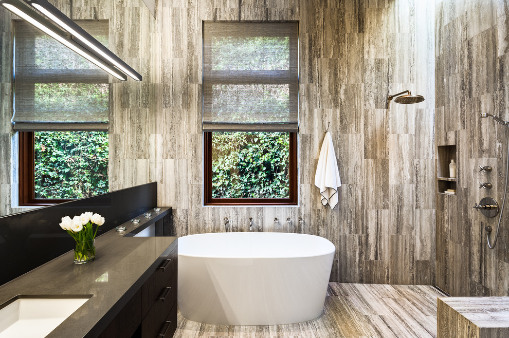 Bild på ett funkis grå grått badrum, med en öppen dusch, släta luckor, ett undermonterad handfat och med dusch som är öppen