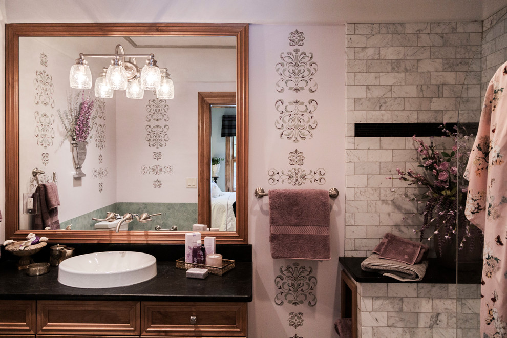Источник вдохновения для домашнего уюта: главная ванная комната среднего размера в стиле фьюжн с фасадами с выступающей филенкой, коричневыми фасадами, открытым душем, серой плиткой, керамической плиткой, розовыми стенами, полом из керамической плитки, настольной раковиной, столешницей из гранита, серым полом, открытым душем и черной столешницей