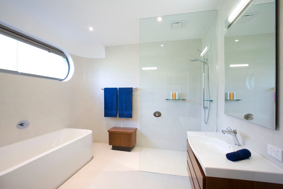 Großes Modernes Badezimmer En Suite mit freistehender Badewanne, integriertem Waschbecken, offener Dusche, Schrankfronten im Shaker-Stil, hellbraunen Holzschränken, Mineralwerkstoff-Waschtisch, weißen Fliesen, Porzellanfliesen, weißer Wandfarbe und Porzellan-Bodenfliesen in Melbourne