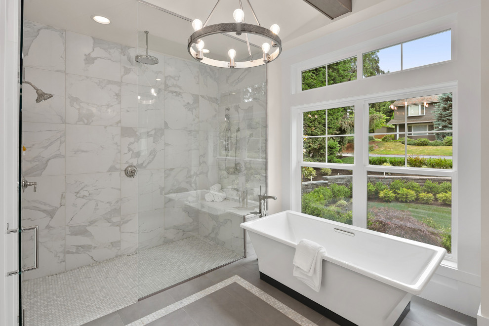 Idéer för att renovera ett mellanstort amerikanskt en-suite badrum, med ett fristående badkar, en kantlös dusch, vit kakel, vita väggar, klinkergolv i keramik, grått golv och dusch med gångjärnsdörr