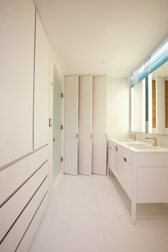 Modelo de cuarto de baño principal actual grande con lavabo bajoencimera, armarios tipo mueble, puertas de armario blancas, baldosas y/o azulejos en mosaico y paredes blancas