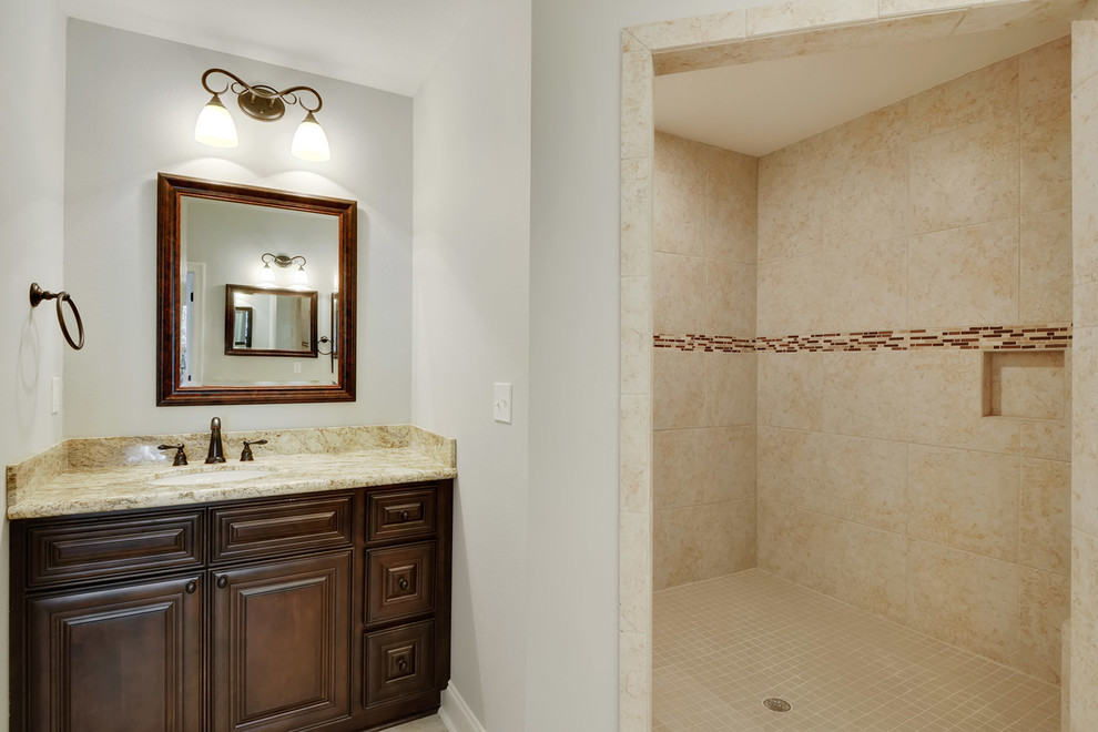 Réalisation d'une grande salle de bain principale tradition avec une douche d'angle, des carreaux de porcelaine et un plan de toilette en granite.