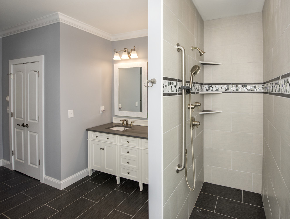 Modelo de cuarto de baño principal moderno con puertas de armario blancas, ducha abierta, paredes grises y ducha abierta