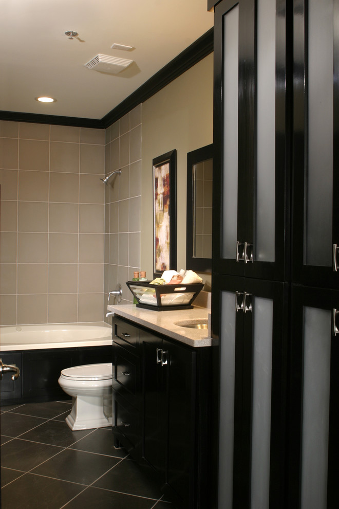 На фото: детская ванная комната среднего размера в современном стиле с фасадами в стиле шейкер, черными фасадами, ванной в нише, раздельным унитазом, серой плиткой, стеклянной плиткой, серыми стенами, полом из известняка, врезной раковиной, столешницей из переработанного стекла, серым полом и серой столешницей с