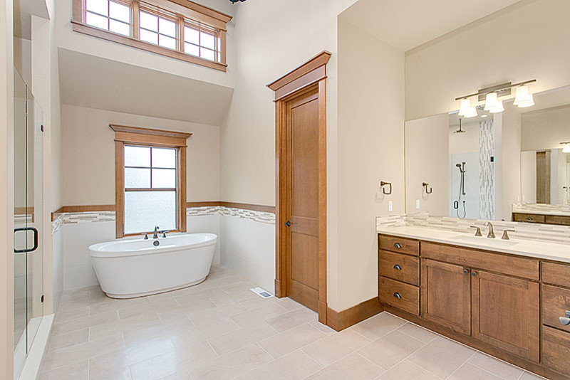 Design ideas for a large classic ensuite bathroom in Seattle with recessed-panel cabinets, dark wood cabinets, a freestanding bath, an alcove shower, a one-piece toilet, white tiles, ceramic tiles, beige walls, porcelain flooring, a submerged sink, solid surface worktops, beige floors and a hinged door.