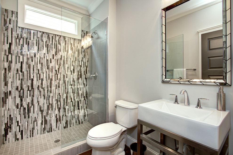 Klassisches Duschbad mit Duschnische, Wandtoilette mit Spülkasten, grauen Fliesen, grauer Wandfarbe, integriertem Waschbecken, dunklem Holzboden und offener Dusche in Charlotte