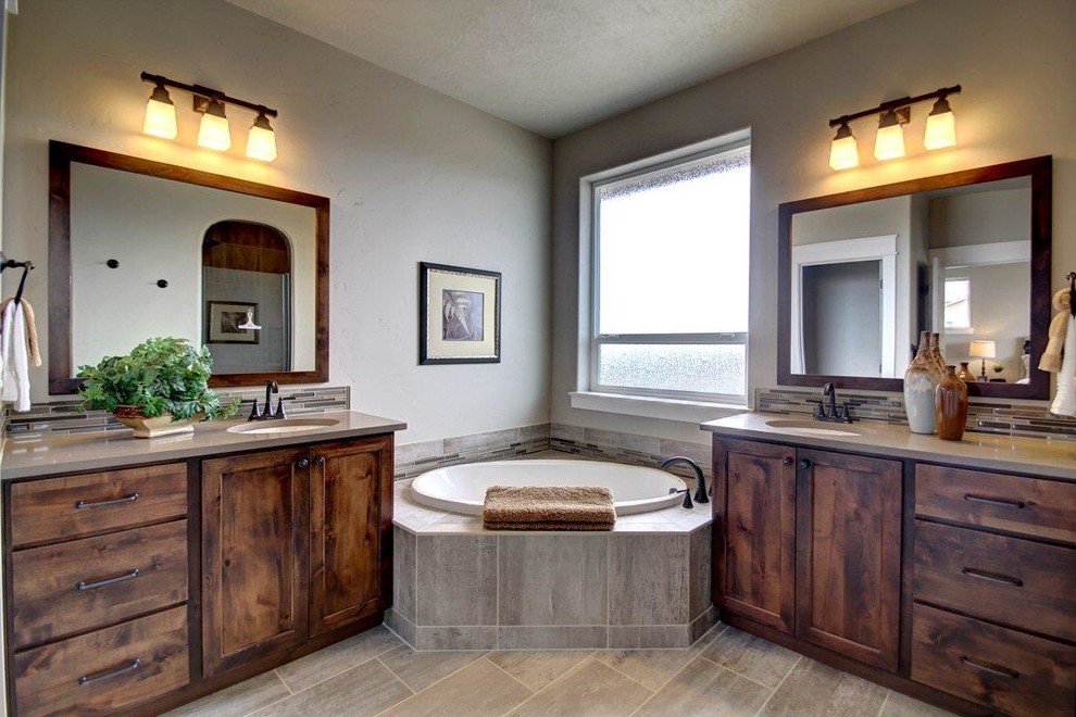 Design ideas for an expansive classic ensuite bathroom in Boise with a submerged sink, distressed cabinets, a built-in bath, ceramic tiles, grey walls and porcelain flooring.
