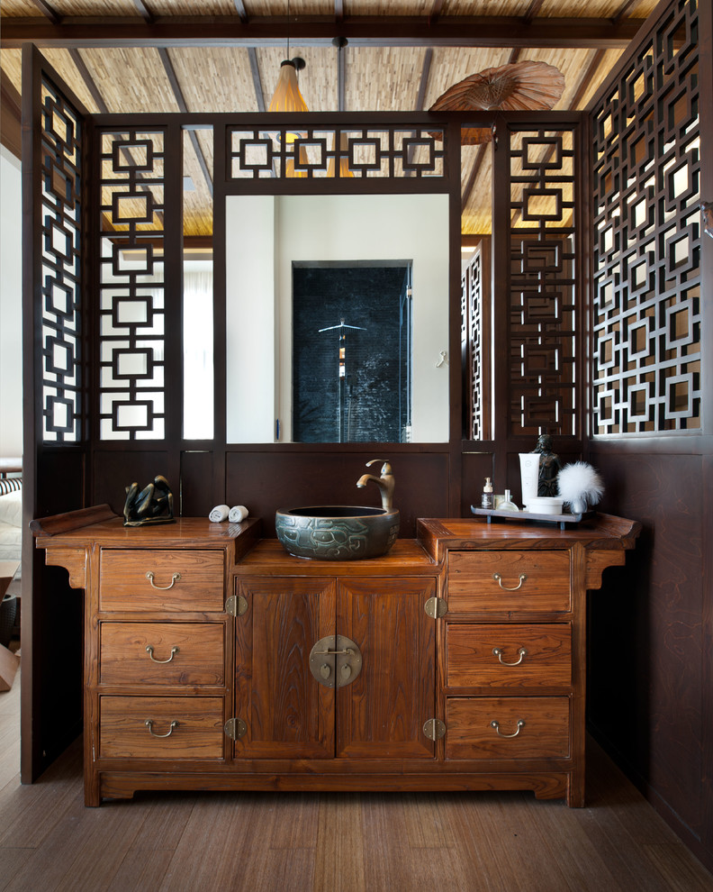 Asiatisches Badezimmer En Suite mit Aufsatzwaschbecken, flächenbündigen Schrankfronten, hellbraunen Holzschränken, Waschtisch aus Holz, offener Dusche, brauner Wandfarbe und braunem Holzboden in Sonstige