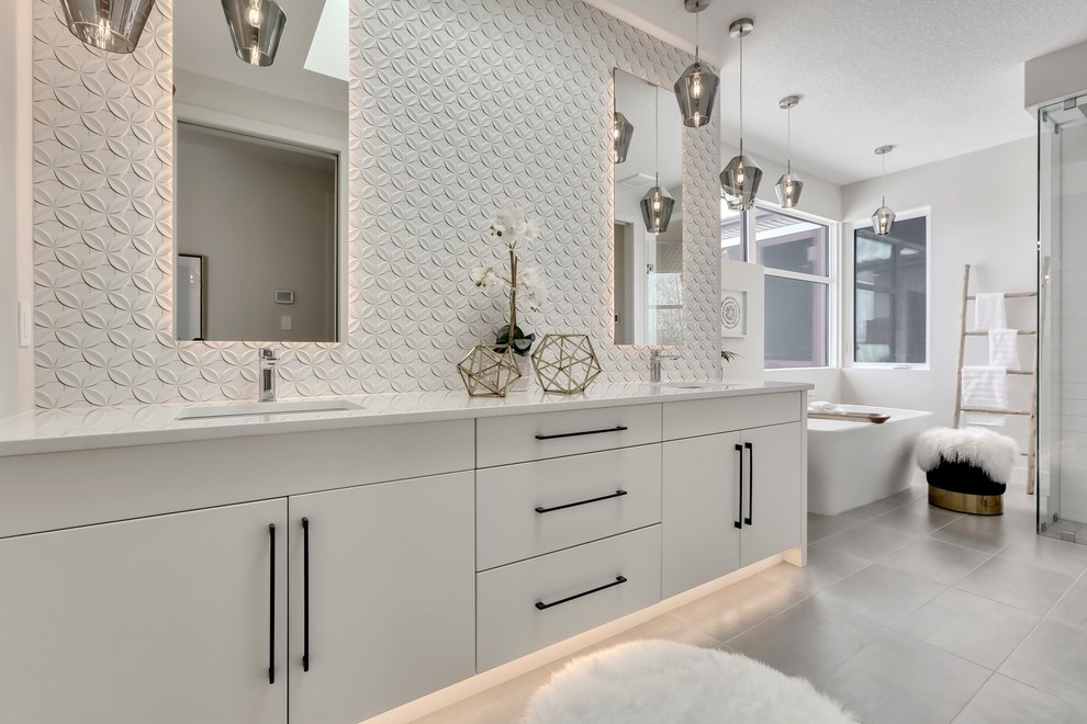 Inspiration for a contemporary ensuite bathroom in Calgary with flat-panel cabinets, white cabinets, a freestanding bath, a corner shower, white tiles, white walls, a submerged sink, grey floors, a hinged door and white worktops.