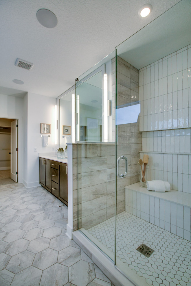 На фото: большая главная ванная комната в стиле неоклассика (современная классика) с плоскими фасадами, фасадами цвета дерева среднего тона, душем в нише, бежевой плиткой, белой плиткой, керамогранитной плиткой, белыми стенами, полом из керамогранита, врезной раковиной, серым полом, душем с распашными дверями, бежевой столешницей, тумбой под одну раковину и встроенной тумбой с