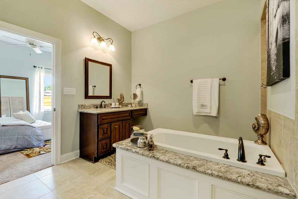 Example of a mid-sized transitional master beige tile and porcelain tile porcelain tile bathroom design in New Orleans with an undermount sink, raised-panel cabinets, dark wood cabinets, granite countertops, a two-piece toilet and gray walls