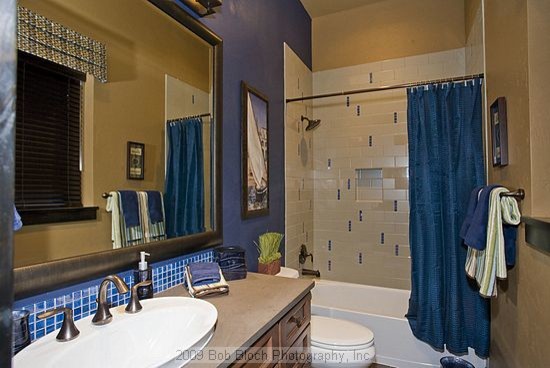 Стильный дизайн: детская ванная комната среднего размера в стиле модернизм с настольной раковиной, фасадами с выступающей филенкой, фасадами цвета дерева среднего тона, столешницей из искусственного кварца, отдельно стоящей ванной, душем над ванной, унитазом-моноблоком, синей плиткой, стеклянной плиткой, синими стенами и полом из керамической плитки - последний тренд