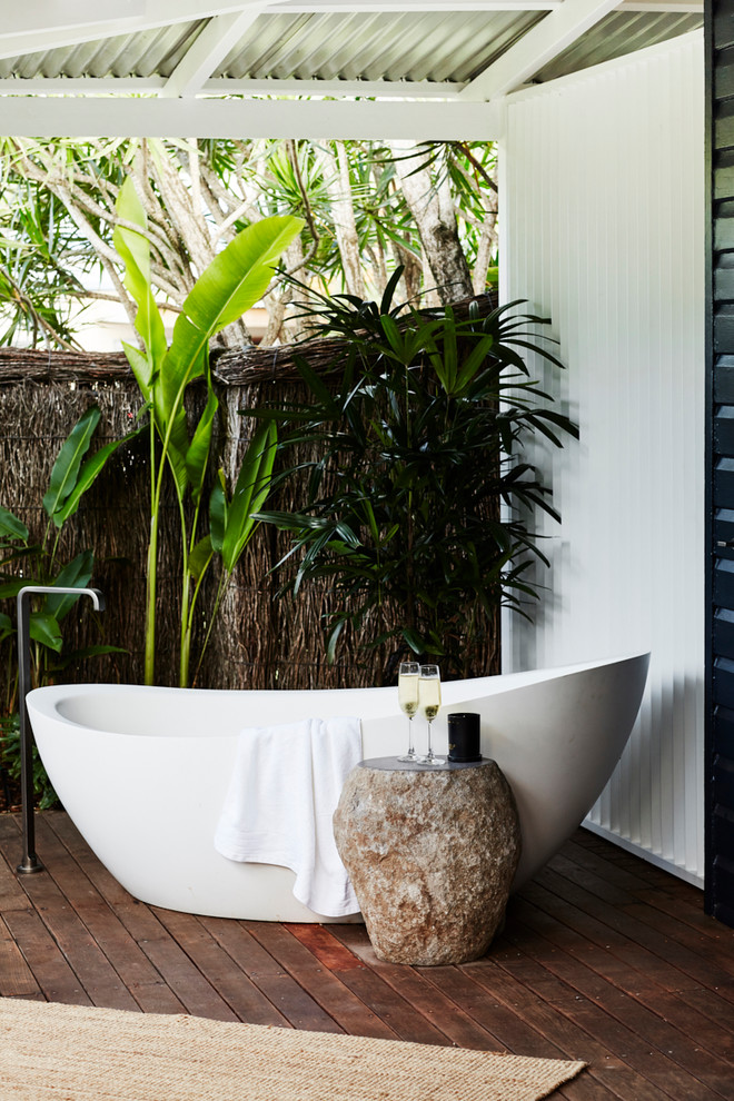 Inspiration för mellanstora moderna badrum, med ett fristående badkar, blå väggar, mörkt trägolv och brunt golv