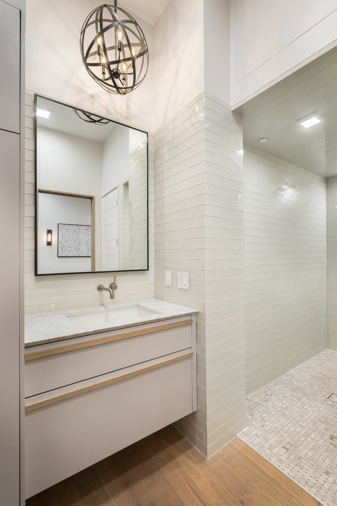 Idée de décoration pour une grande salle de bain design avec une baignoire indépendante, une douche à l'italienne, un carrelage en pâte de verre, un mur gris, un sol en bois brun, un lavabo encastré, un plan de toilette en marbre et aucune cabine.