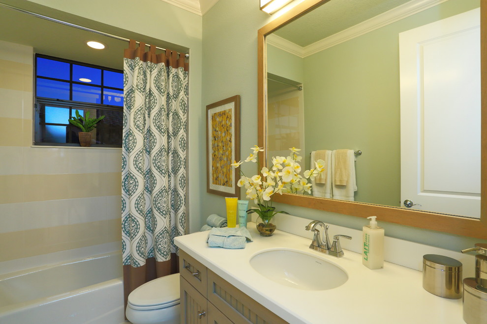 Bild på ett mellanstort vintage badrum, med ett undermonterad handfat, luckor med profilerade fronter, skåp i mellenmörkt trä, bänkskiva i akrylsten, ett platsbyggt badkar, en dusch/badkar-kombination, en toalettstol med separat cisternkåpa, flerfärgad kakel, porslinskakel, gröna väggar och klinkergolv i porslin