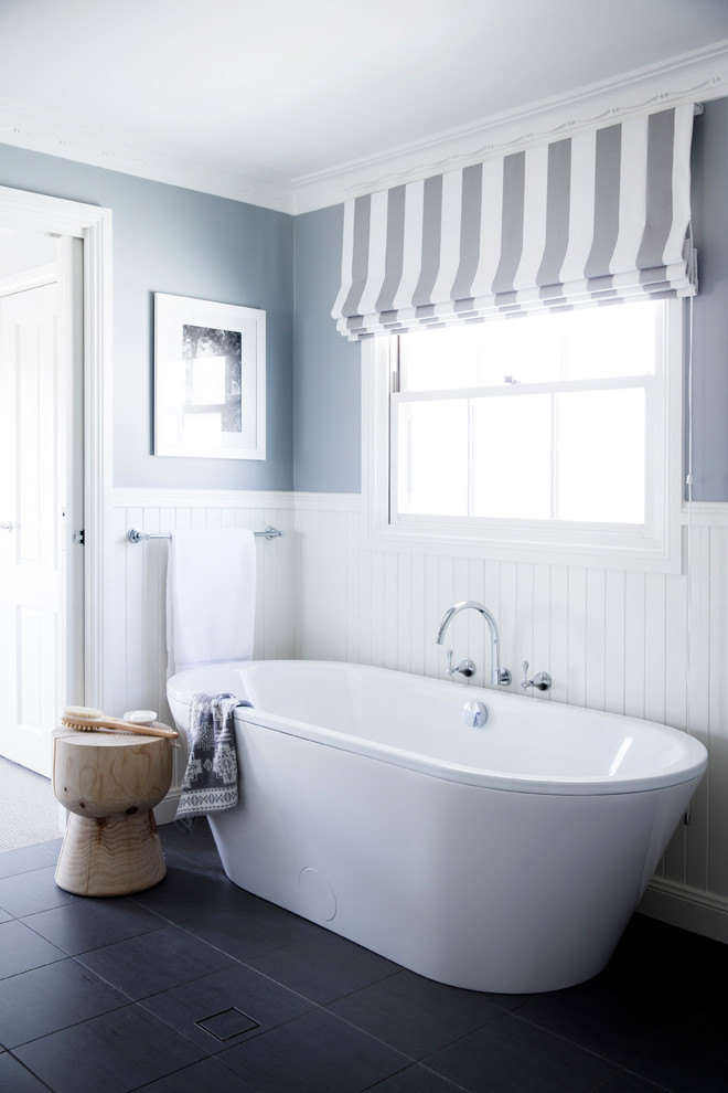 Immagine di una stanza da bagno costiera con vasca freestanding e pareti grigie