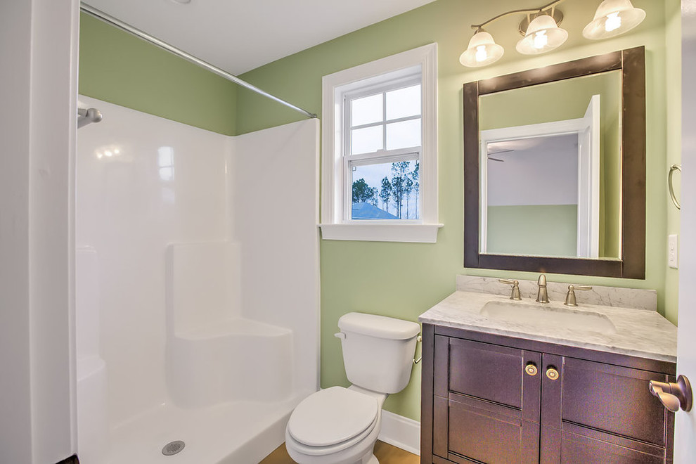 Exempel på ett litet klassiskt badrum med dusch, med möbel-liknande, skåp i mörkt trä, en dusch i en alkov, en toalettstol med separat cisternkåpa, beige kakel, porslinskakel, gröna väggar, klinkergolv i porslin, ett undermonterad handfat, marmorbänkskiva och brunt golv