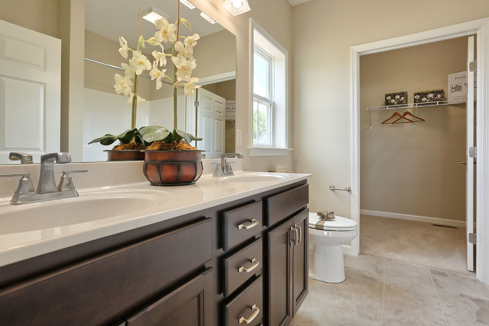 Photo of a large traditional ensuite bathroom in Other with dark wood cabinets, an alcove shower, a two-piece toilet, beige walls, ceramic flooring, an integrated sink, marble worktops and a shower curtain.