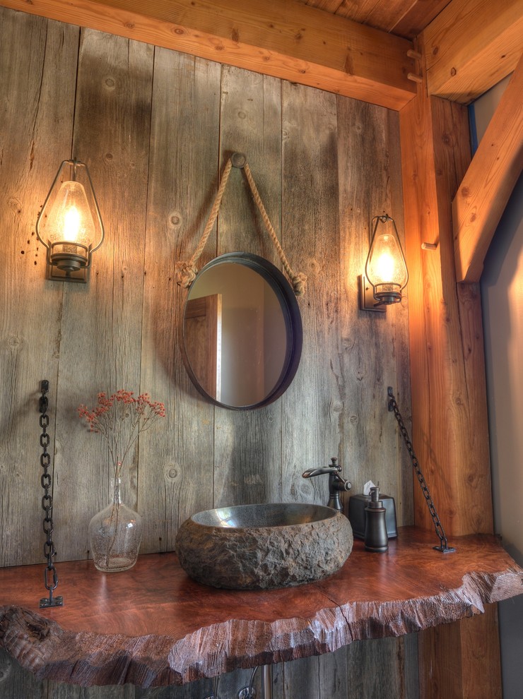 Aménagement d'une petite salle d'eau montagne avec un plan de toilette en bois.