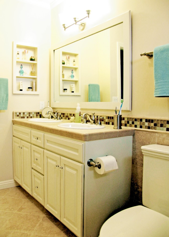 Idéer för ett litet klassiskt badrum med dusch, med ett nedsänkt handfat, luckor med upphöjd panel, vita skåp, kaklad bänkskiva, en toalettstol med separat cisternkåpa, beige kakel, porslinskakel, beige väggar och klinkergolv i porslin