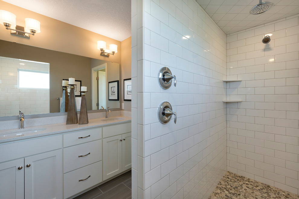 Imagen de cuarto de baño tradicional renovado con puertas de armario blancas, baldosas y/o azulejos blancos, paredes grises y encimera de cuarcita