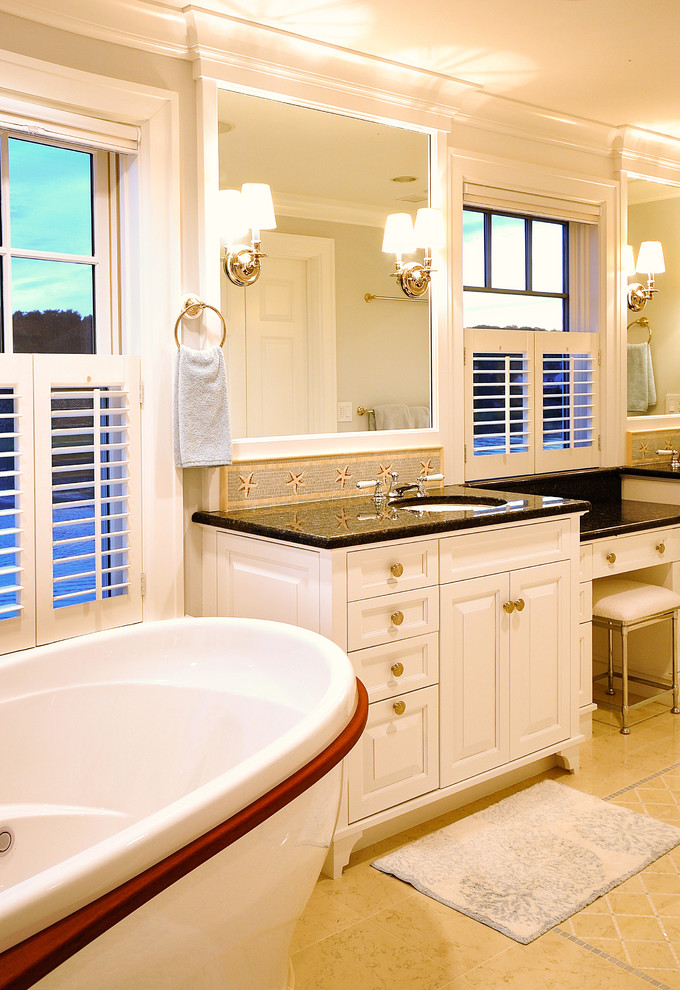 Пример оригинального дизайна: большая главная ванная комната в стиле неоклассика (современная классика) с белыми фасадами, отдельно стоящей ванной, угловым душем, бежевыми стенами, полом из керамогранита, накладной раковиной, мраморной столешницей, бежевым полом, фасадами в стиле шейкер, бежевой плиткой, стеклянной плиткой и душем с распашными дверями