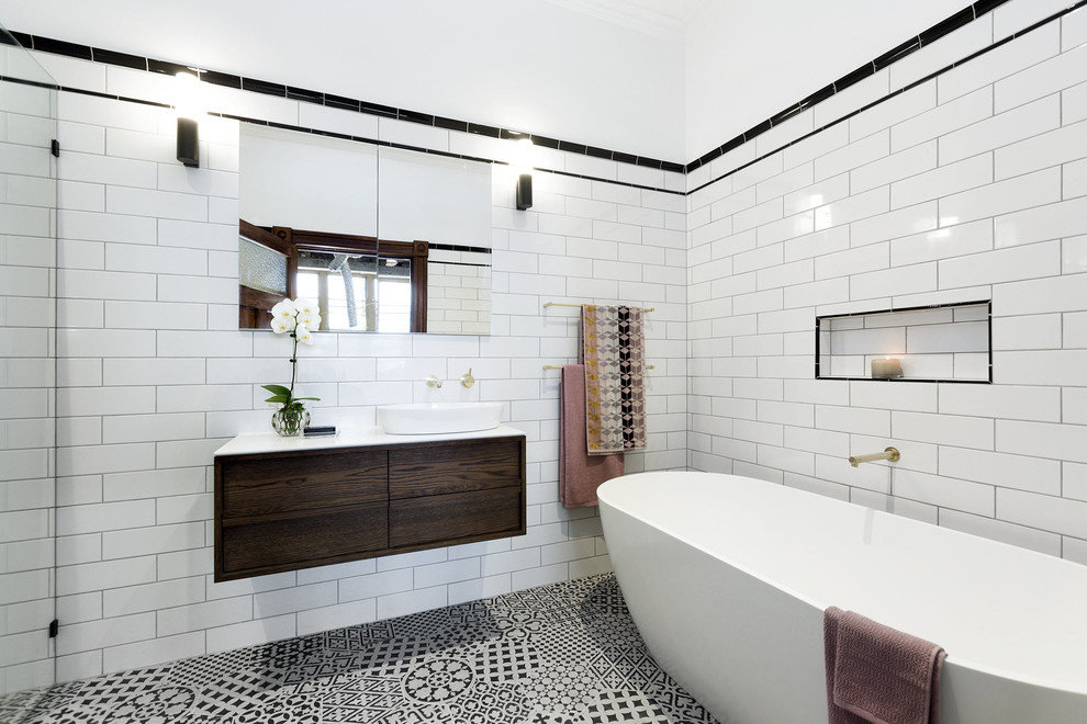 Inspiration for a contemporary bathroom in Melbourne with flat-panel cabinets, dark wood cabinets, a freestanding bath, an alcove shower, black and white tiles, white tiles, metro tiles, white walls and a vessel sink.