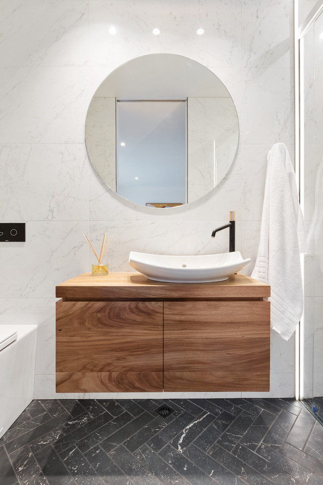 Idee per una stanza da bagno design con ante lisce, ante in legno scuro, doccia alcova, piastrelle bianche, lavabo a bacinella e pavimento nero