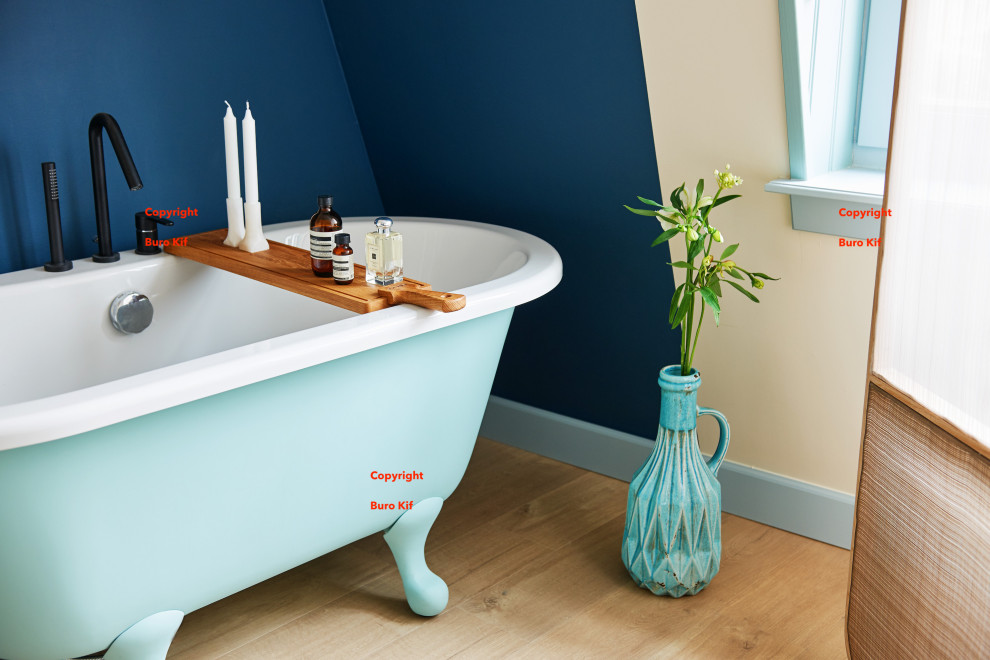 Exempel på ett mellanstort modernt badrum, med ett badkar med tassar, blå väggar, ljust trägolv och brunt golv