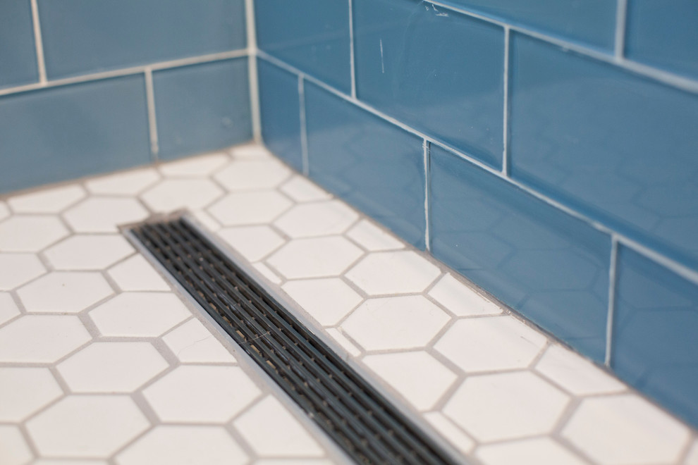 Esempio di una stanza da bagno con ante di vetro, ante nere, doccia ad angolo, piastrelle blu, piastrelle di vetro, pareti blu e pavimento con piastrelle a mosaico