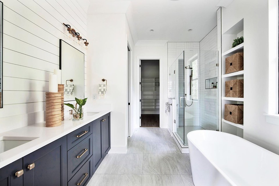 Corner shower - mid-sized farmhouse master white tile and subway tile porcelain tile and white floor corner shower idea in Charlotte with recessed-panel cabinets, black cabinets, a hot tub, a wall-mount toilet, white walls, an undermount sink, quartz countertops, a hinged shower door and white countertops